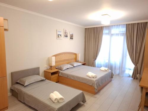 a hotel room with two beds and a window at Studio Sea Breeze Veranda in Santa Marina in Sozopol