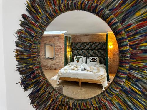a bedroom with a bed and a mirror at Mama Souiri Hotel in Essaouira