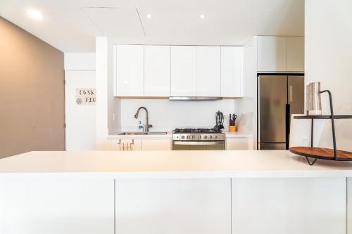 a white kitchen with white cabinets and a sink at Casa Flor Cabo Your Private Oasis in Cabo San Lucas