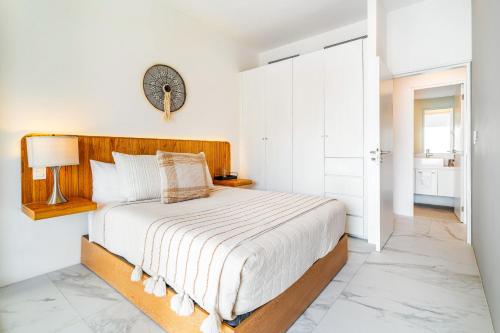 a bedroom with a bed and a clock on the wall at Casa Flor Cabo Your Private Oasis in Cabo San Lucas
