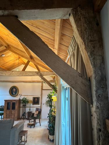 a living room with a wooden ceiling and a room with a couch at The Barn in Romsey