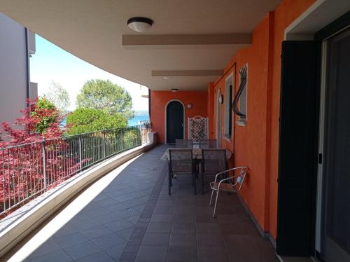 a balcony with orange walls and a table and chairs at Super Location front lake in Sirmione
