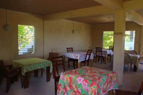 una sala da pranzo con tavoli, sedie e finestre di Big Sky Lodge a Crochu