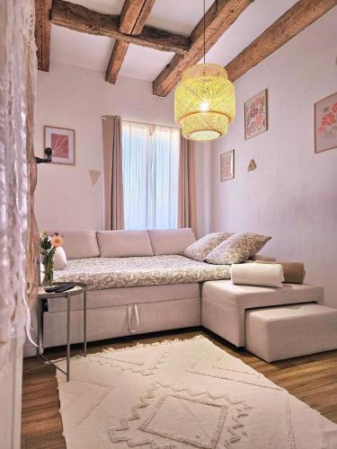 a living room with a couch and a chandelier at L'Atypique des Remparts in Ensisheim