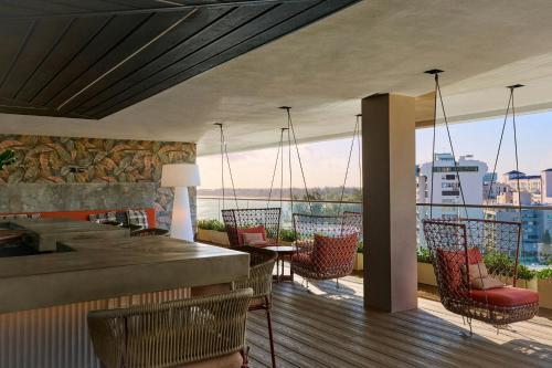 a restaurant with a balcony with a view of the ocean at Casa Costera, Isla Verde Beach, Apartments by Marriott Bonvoy in San Juan