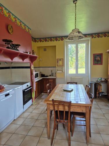 une cuisine avec une table et des chaises dans une pièce dans l'établissement Les Marronniers, wifi, 10 min from Martel, à Condat
