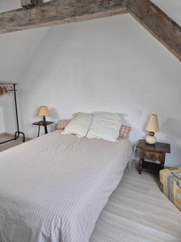 - une chambre avec un lit avec des draps blancs et 2 lampes dans l'établissement Les Marronniers, wifi, 10 min from Martel, à Condat