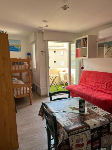 un salon avec un lit et une table ainsi qu'une chambre dans l'établissement Studio avec parking clim Cap d Agde, au Cap d'Agde