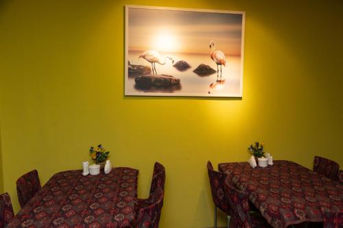 a dining room with two tables and a picture of flamingos at Flamingo Hotel in Baku