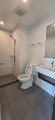a bathroom with a toilet and a sink at Grene Donmueng in Thung Si Kan