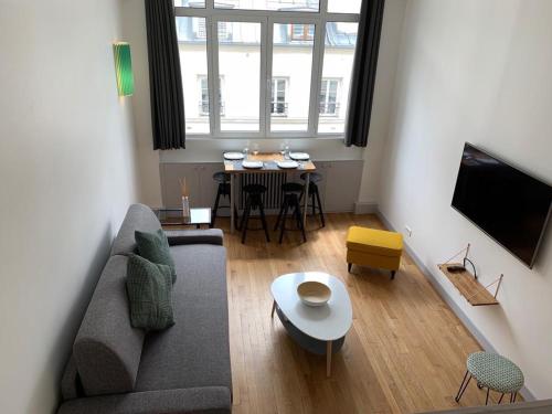 un salon avec un canapé et une table dans l'établissement Superbe appartement 4 personnes au centre de Paris, à Paris