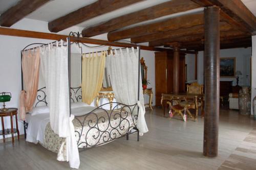 a bedroom with a canopy bed with white curtains at Castello Scandeluzza in Rome