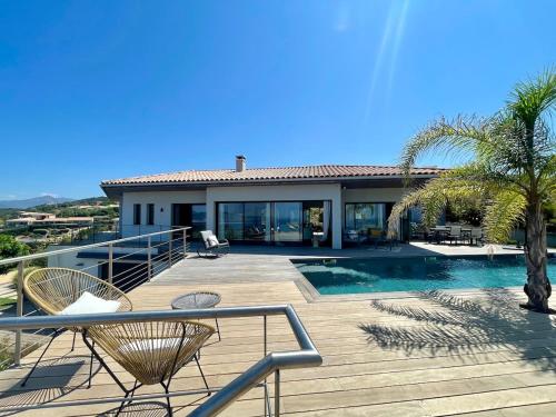 une maison avec une terrasse et une piscine dans l'établissement Villa Mylena avec vue sur la baie d'Ajaccio, à Albitreccia