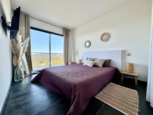 une chambre avec un lit et une grande fenêtre dans l'établissement Villa Mylena avec vue sur la baie d'Ajaccio, à Albitreccia