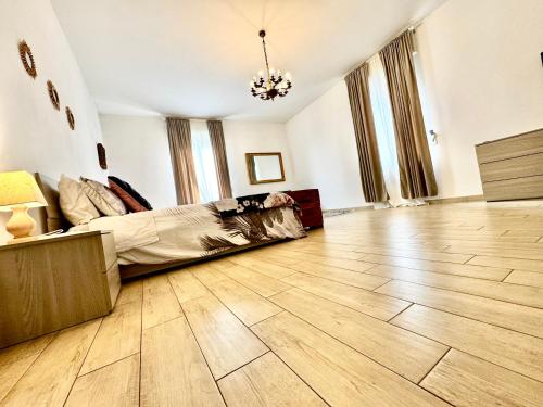 a bedroom with a bed and a wooden floor at La casa di Sarah aspetta voi in Naples