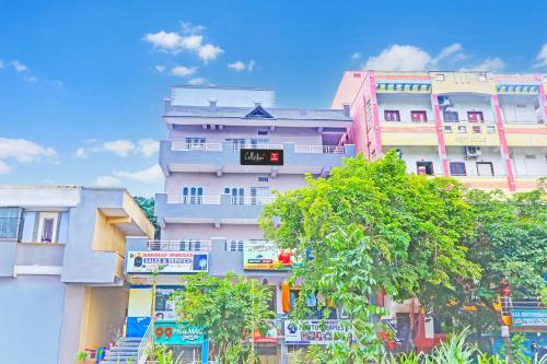 a tall apartment building with a clock on it at Collection O De Alphabet Hotel UMCC in Hyderabad