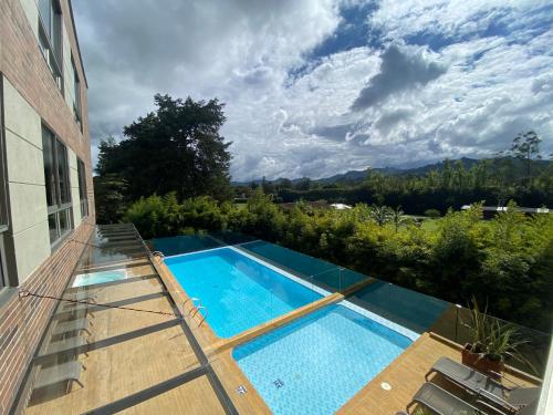 a swimming pool on the side of a house at Suite de Lujo en Llano Grande - Piscina, jacuzzi, Turco, Gimnasio in Rionegro