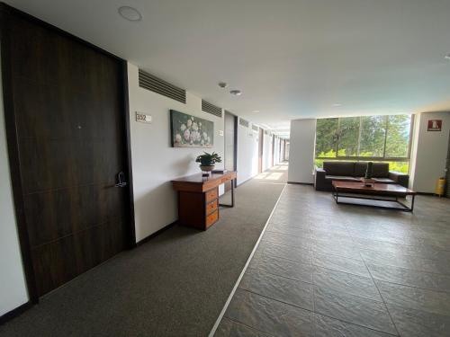 an office hallway with a couch and a table at Suite de Lujo en Llano Grande - Piscina, jacuzzi, Turco, Gimnasio in Rionegro