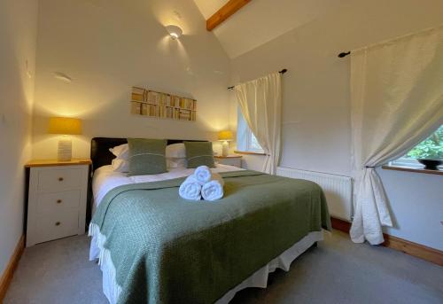 a bedroom with a bed with two towels on it at Deer Close Cottage in Keswick