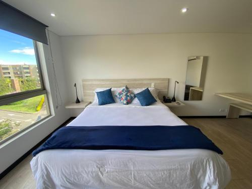 a bedroom with a large bed with a large window at Suite de Lujo en Llano Grande - Piscina, jacuzzi, Turco, Gimnasio in Rionegro