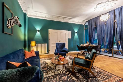 een woonkamer met een blauwe bank en een tafel bij FABEL Apartments am Zoo in Berlijn