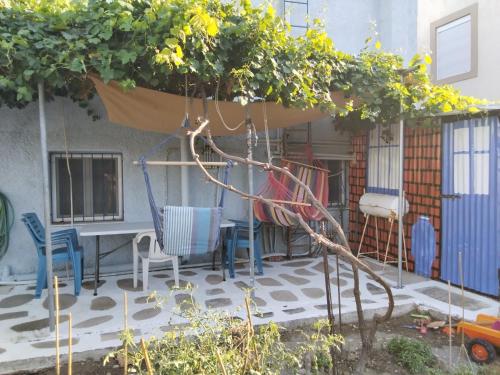 a patio with chairs and a table and a swing at Dora's House in Chios