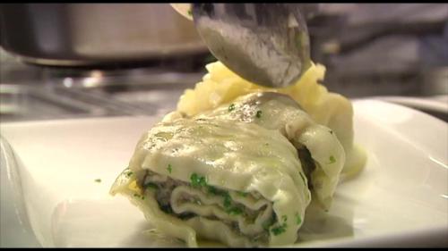 a piece of food on a white plate with a knife at Gasthof Traube in Aspach