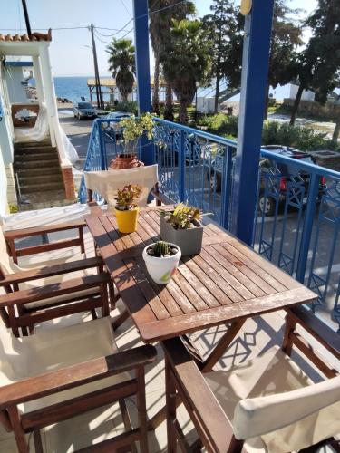 a wooden table with potted plants on a balcony at Dora's House in Chios