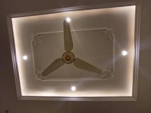 a ceiling fan is in a room with a light at The Warmer House Islamabad Airport in Islamabad
