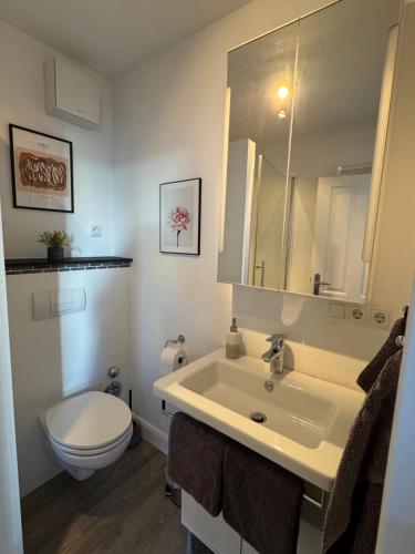 a bathroom with a white sink and a toilet at City Apartments am Rhein in Bonn