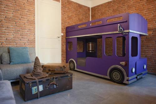un bus de jouets est assis dans une pièce avec des bagages dans l'établissement HARRY POTTER A LA PLAGE, à Toulon