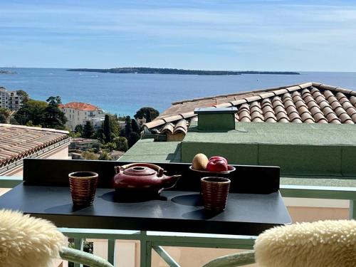 - une table avec des bols et des pommes sur le balcon dans l'établissement Cannes Passion, à Cannes