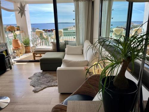 un salon avec un canapé et une plante en pot dans l'établissement Cannes Passion, à Cannes