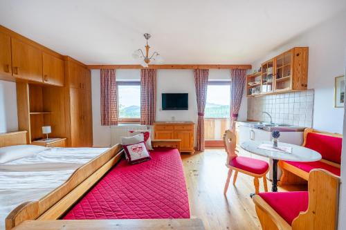 a bedroom with a large bed with a red rug at Kerschdorferhof - Erlebnisbauernhof in Feldkirchen in Kärnten
