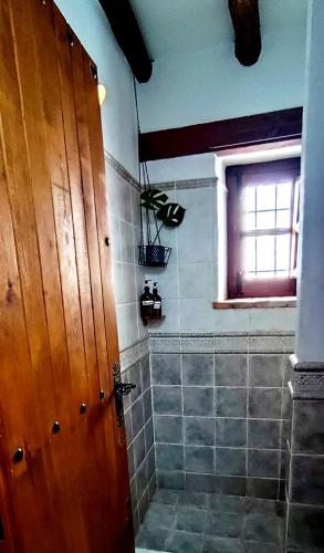 a bathroom with a shower and a wooden door at Casa Balcón in Granada