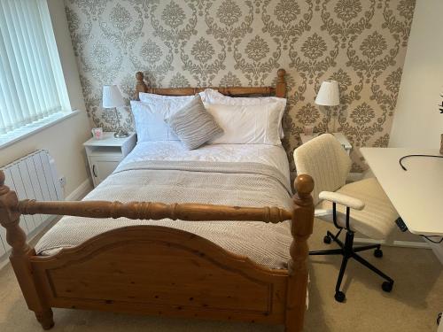 a bedroom with a wooden bed and a desk and a table and chair at Cosy 2 Bed House near Birmingham Airport & NEC in Birmingham