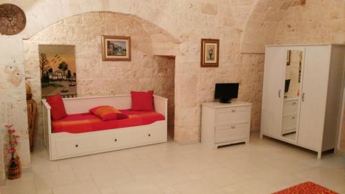 - une chambre avec un lit, une commode et une télévision dans l'établissement B&B La Pietra, à Castellana Grotte