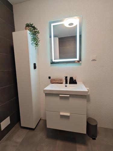a bathroom with a white sink and a mirror at Meraki Apartment Kostrena two bedrooms in Kostrena