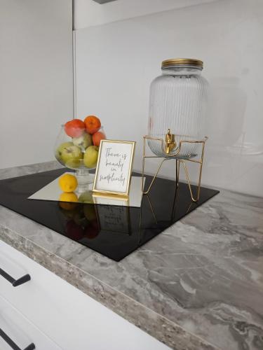 a table with a plate of fruit and a glass jar at Meraki Apartment Kostrena two bedrooms in Kostrena