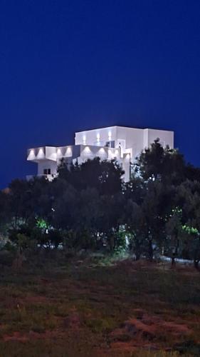 a white building on top of a hill at night at Montebello Inn apartments in Ulcinj