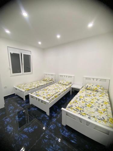three beds sitting in a room with a row at Montebello Inn apartments in Ulcinj