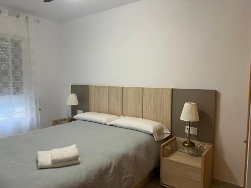 a bedroom with a large bed with two towels on it at Iberia home beach in Águilas