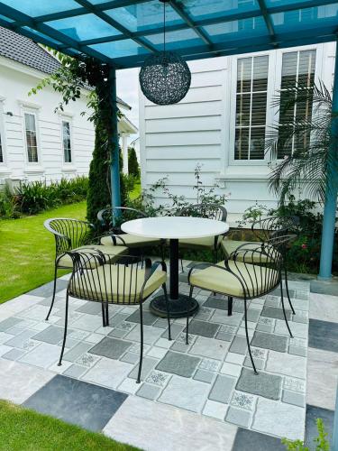 a patio with a table and chairs under a pergola at Phòng Đôi tại Happy Villa - Vườn Vua gồm ăn sáng và ăn tối in Ðồng Phú