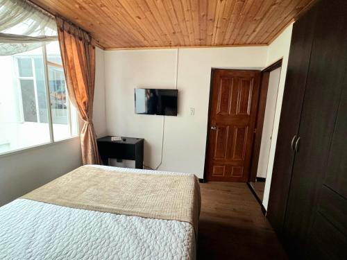 a bedroom with a bed and a tv and a window at Oporto 83 in Bogotá