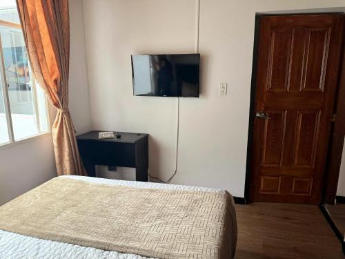 a bedroom with a bed and a flat screen tv at Oporto 83 in Bogotá