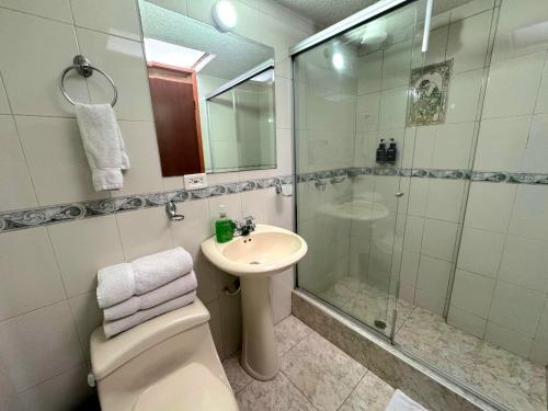 a bathroom with a shower and a toilet and a sink at Oporto 83 in Bogotá