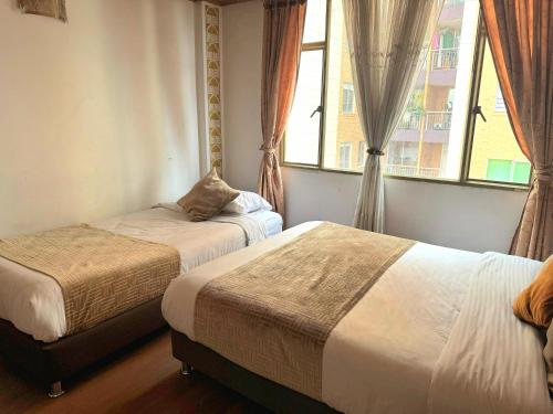 a bedroom with two beds and a window at Oporto 83 in Bogotá