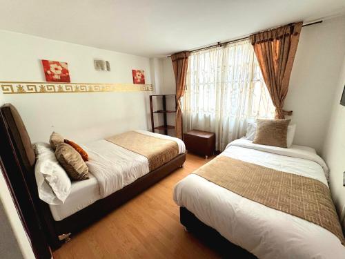 a bedroom with two beds and a window at Oporto 83 in Bogotá