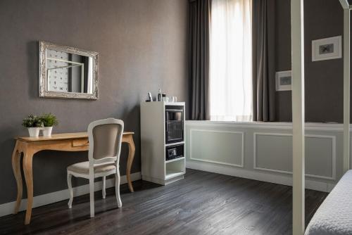 a bedroom with a desk and a chair and a mirror at Maxxim Hotel & Loft in Ferrara
