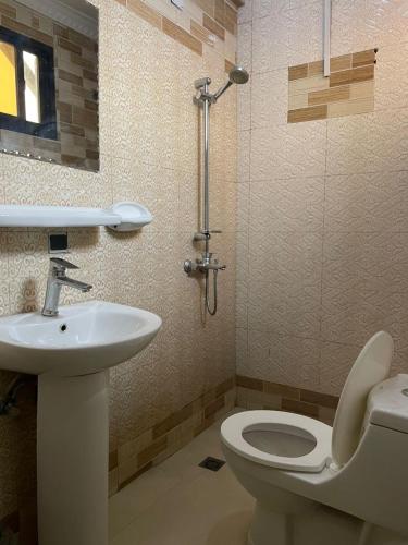 a bathroom with a toilet and a sink and a shower at DAVAROXE Appartements Lingwala RTNC in Kinshasa
